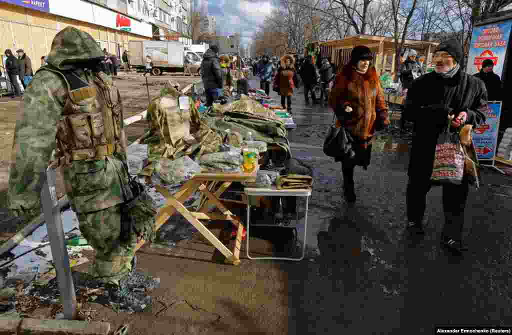 Люди совершают покупки на импровизированном рынке в Мариуполе. 16 февраля 2023 года