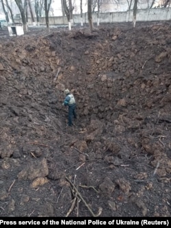 Сапёр правярае варонку ад выбуху каля дзіцячага шпіталю ў Марыюпалі пасьля бамбаваньня 9 сакавіка 2022