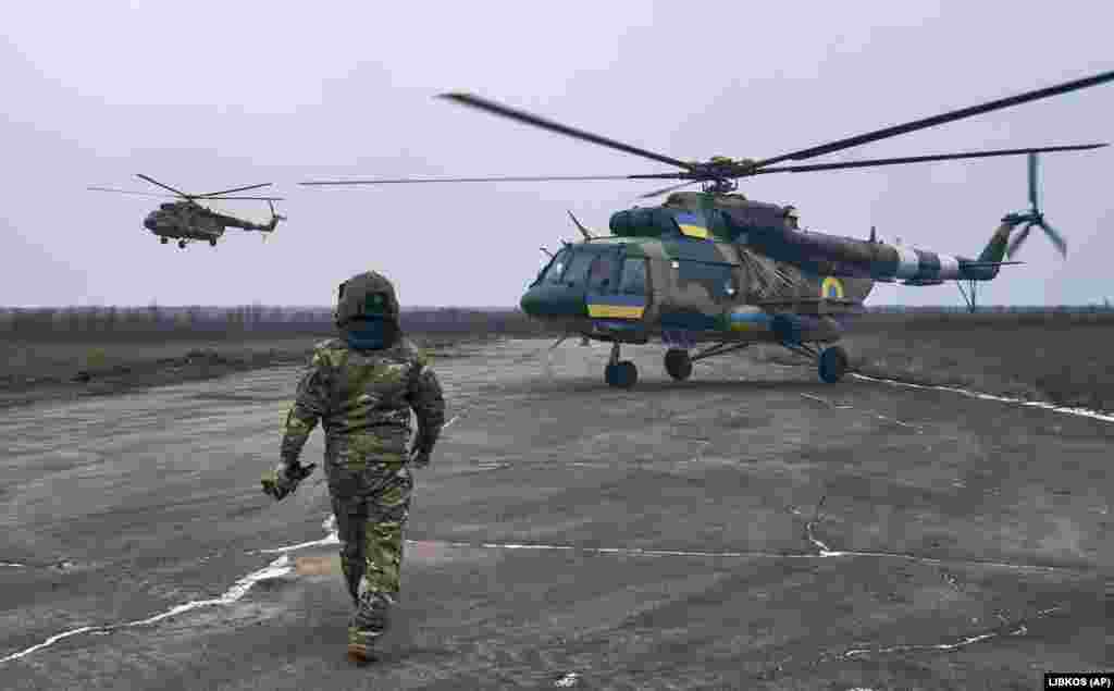 Украинский пилот приближается к своему вертолету на неизвестной военной авиабазе в Херсонской области 8 января. Украина использует вертолеты советской эпохи, такие как Ми-8, Ми-17 и ударные вертолеты Ми-24П, в боях с российскими войсками.