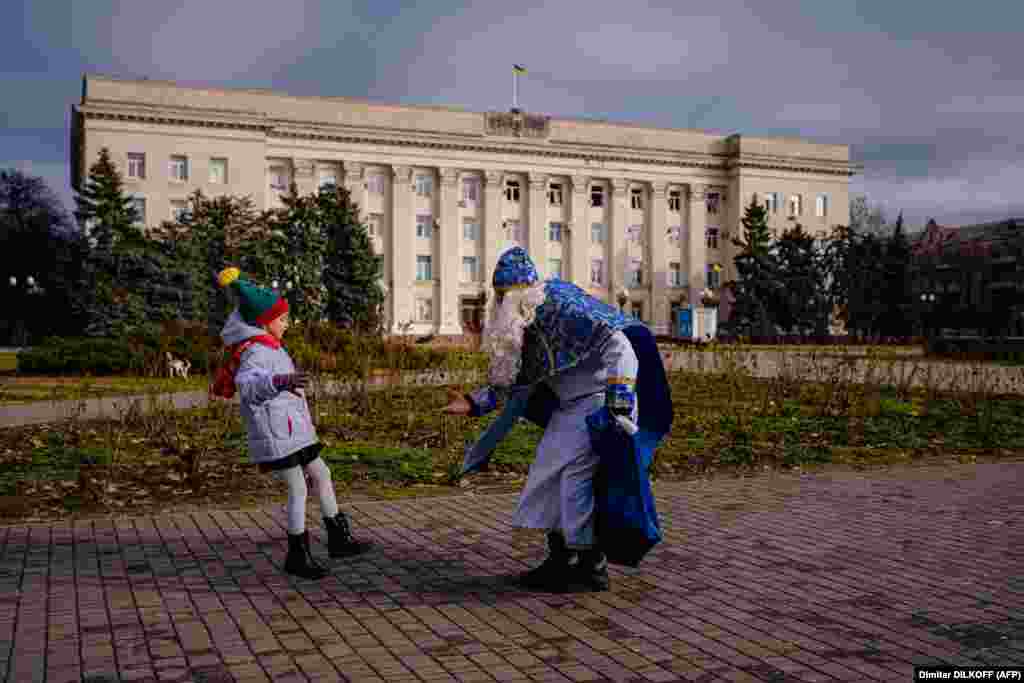 Девочка встречает мужчину в костюме Святого Николая в Херсоне, Украина.