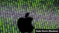 A 3D printed Apple logo is seen in front of a displayed cyber code - generic