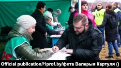 Ілюстрацыйнае фота. Прапагандыст Рыгор Азаронак ставіць подпіс у падтрымку вылучэньня Аляксандра Лукашэнкі кандыдадатам у прэзыдэнты. 7 лістапада 2024 году