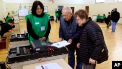 Ілюстрацыйнае фота. Людзі аддаюць свае бюлетэні на выбарчым участку падчас парлямэнцкіх выбараў у Тбілісі, Грузія, 26 кастрычніка 2024 году