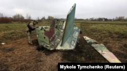 Украинский военный осматривает обломки российского боевого самолета Су-25. Фото архивное