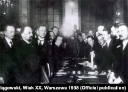 Падчас падпісаньня Рыскай дамовы, згодна зь якой заходнія землі Беларусі перадаваліся пад уладу Польшчы, а ўсходнія ўваходзілі ў склад РСФСР. Рыга, 18 сакавіка 1921 году