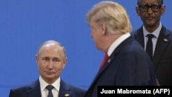 Donald Tramp Buenos-Ayresdə G20 liderlərinin sammiti zamanı "ailə şəkli" çəkdirərkən Vladimir Putinə baxır. 2018