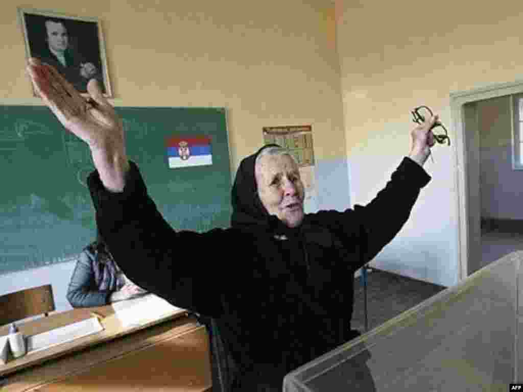 An ethnic Kosovo Serb woman cast her ballot and gestures as she votes at a polling station in the village of Gracanica 03 February 2008. The Serbian minority in Kosovo voted in the Serbian presidental elections held today. Serbia