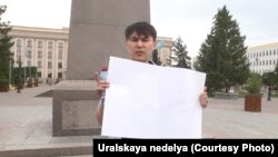 Оралдағы алаңда ақ плакат ұстап тұрған белсенді Аслан Сагутдинов. 6 мамыр 2019 жыл.