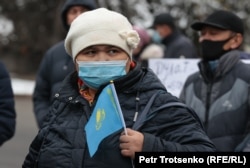 Қазақстан туы тәрізді жалауша ұстап, митингіде тұрған адам. Алматы, 14 қараша 2020 жыл.