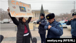 Qaznews24 сатиралық паблигінің авторы Темірлан Еңсебекке қолдау білдіріп, пикетке шыққан журналист Әсем Жәпішеваға полиция келген сәт. Алматы, 20 қаңтар, 2025 жыл.