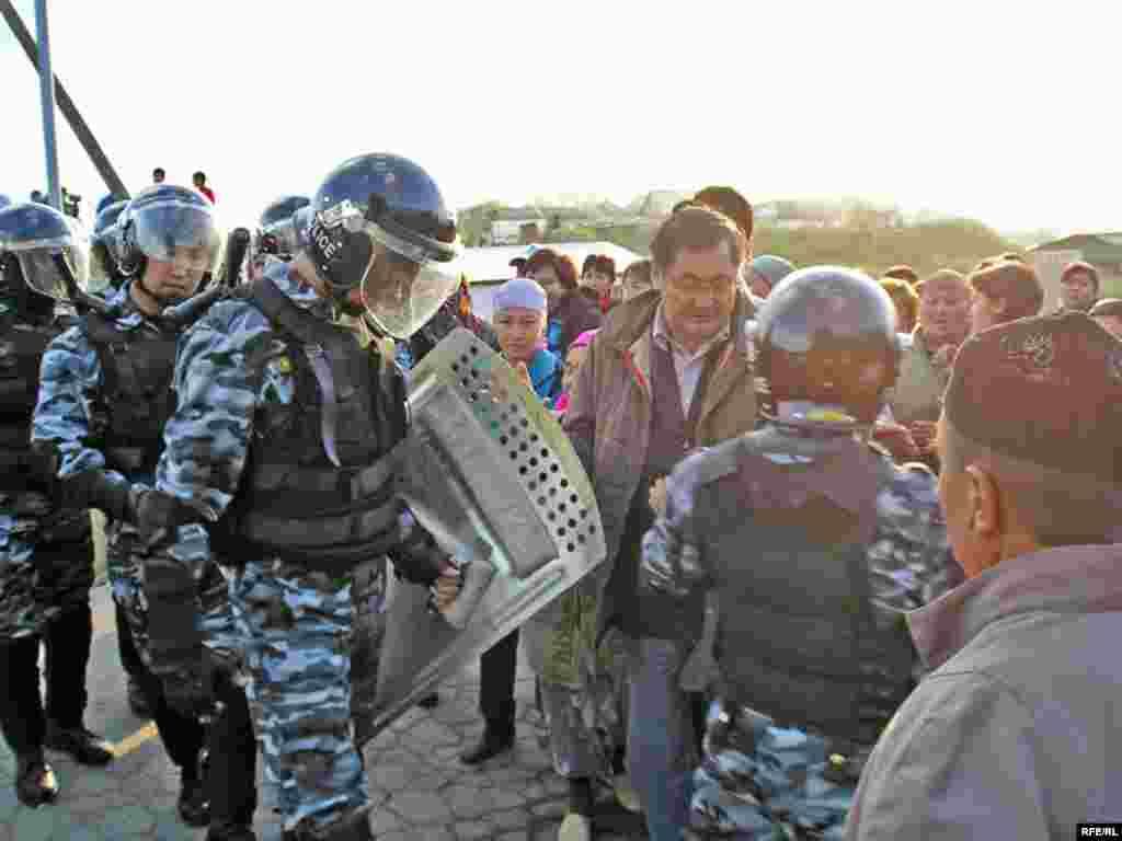 Оппозиция белсендісі Рысбек Сәрсенбай (ортада) полицияны даулы мәселені келіссөз арқылы бейбіт жолмен шешуге үндеді.