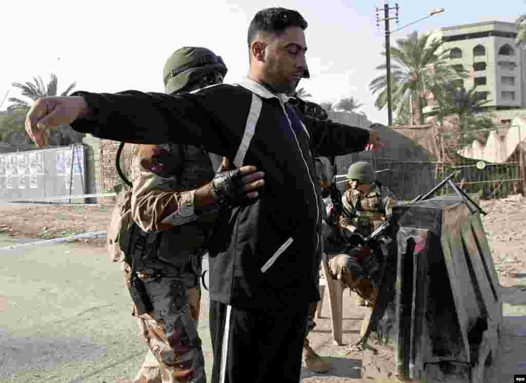 An Iraqi man goes through a security check before voting at a pollling station in Baghdad on Thursday 15 December 2005. Iraqis headed for polling stations Thursday to elect the first permanent parliament since the 2003 fall of Saddam Hussein's regime