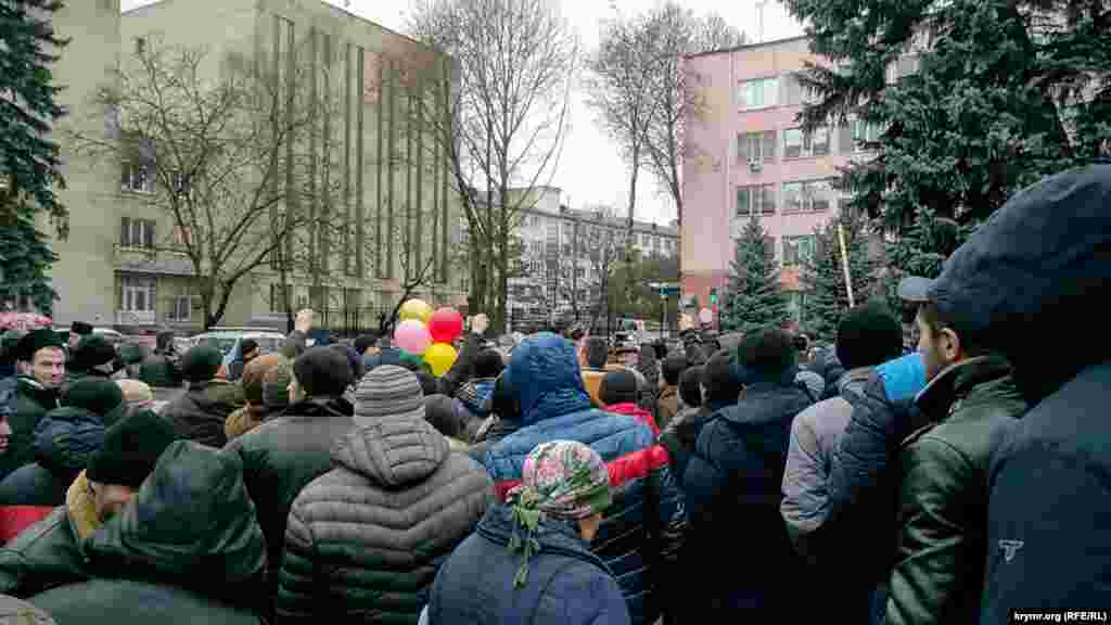 Возле доски почета собрались десятки активистов, пришедших выразить слова благодарности и поддержки адвокату